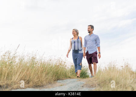 Donna incinta in spiaggia con il marito divertendosi Foto Stock