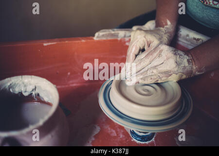 Lavorare in un laboratorio di ceramiche, womans mani creazione di ceramica. Foto Stock