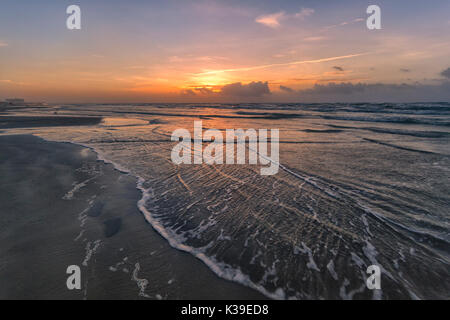 Onde si infrangono sul golfo del Messico al sorgere del sole sulle spiagge di Port Aransas Texas Foto Stock