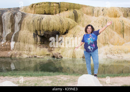 Donna asiatica in posa da una terrazza gethermal in Hot Springs State Park, Thermopolis, WY Foto Stock