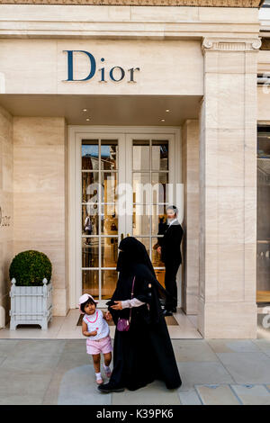 Una donna musulmana di indossare il burka passeggiate passato la Dior Fashion Store In New Bond Street, Londra, Regno Unito Foto Stock