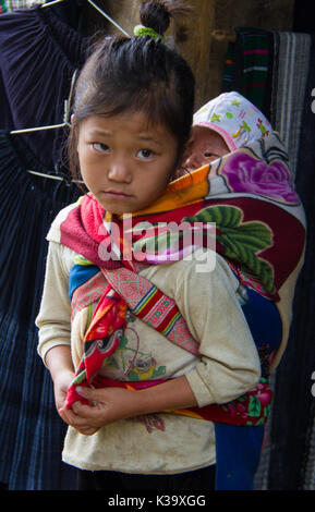 Vietnamita porta bambino piccolo fratello sulla sua schiena, mentre cercano plaintive, ma mai a mendicare il Ott 21, 2011 Foto Stock