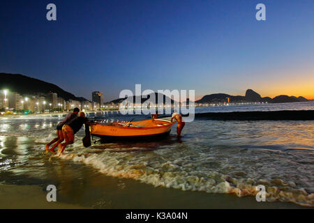 Fishermans entra in mare la mattina presto all'alba, Rio de Janeiro, Brasile Foto Stock