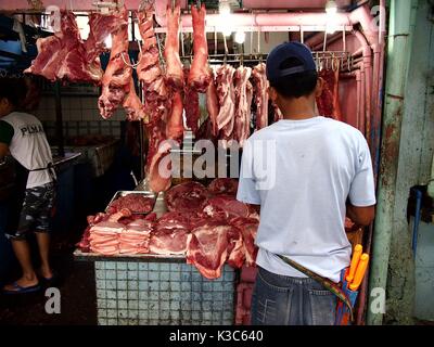 MARIKINA City, Filippine - 28 agosto 2017: un macellaio di carne vende carni fresche in un negozio in un mercato pubblico. Foto Stock