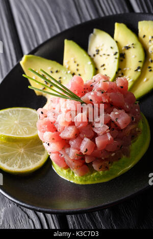 Tartare di tonno fresco con avocado, wasabi e calce closeup su di una piastra verticale. Foto Stock