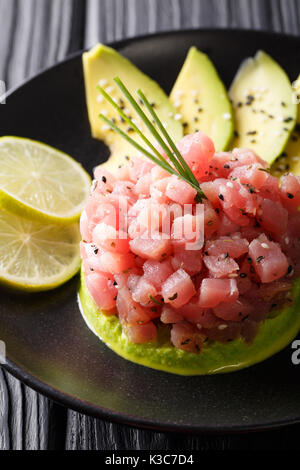 Tartare di tonno servita con avocado e calce macro su di una piastra verticale. Foto Stock