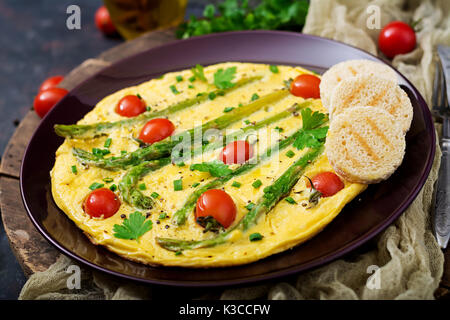 La frittata (frittata) con pomodori, gli asparagi e le cipolle verdi Foto Stock