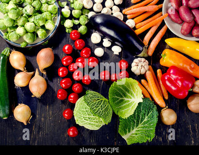 Verdure organiche su tavola in legno rustico. Mangiare sano concetto. Vista superiore Foto Stock