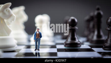 L'uomo miniatura all'interno di un gioco di scacchi, concept Foto Stock