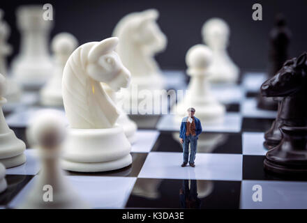 L'uomo miniatura all'interno di un gioco di scacchi, concept Foto Stock