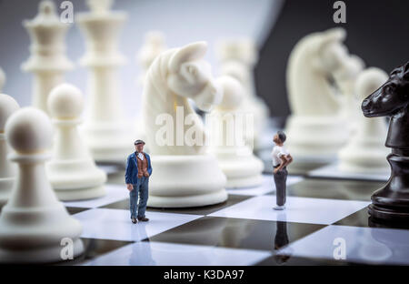 Gli uomini miniatura all'interno di un gioco di scacchi, concept Foto Stock