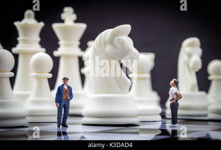 Gli uomini miniatura all'interno di un gioco di scacchi, concept Foto Stock