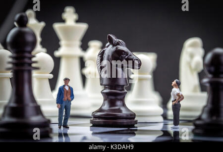 Gli uomini miniatura all'interno di un gioco di scacchi, concept Foto Stock