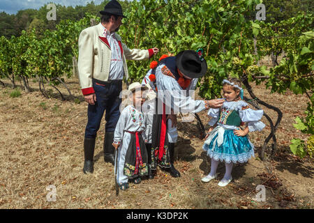 Blatnice pod Svatym Antoninem, Moravia meridionale, Repubblica Ceca, padre e nonno con bambini in costume tradizionale folk, in vigna Foto Stock