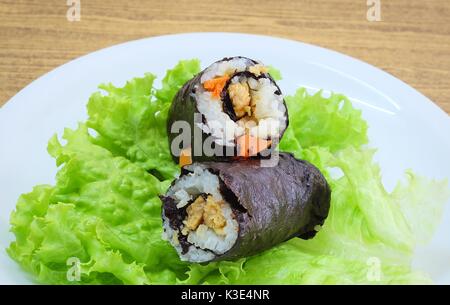 La cucina giapponese, Vagetarian tradizionale di riso giapponese maki sushi Roll roba con tofu e carote avvolte in Nori alghe servita sulla quercia verde. Foto Stock