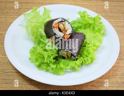 La cucina giapponese, Vagetarian tradizionale di riso giapponese maki sushi Roll roba con tofu e carote avvolte in Nori alghe servita sulla quercia verde. Foto Stock