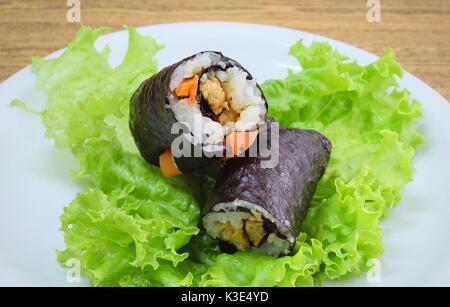 La cucina giapponese, Vagetarian tradizionale di riso giapponese maki sushi Roll roba con tofu e carote avvolte in Nori alghe servita sulla quercia verde. Foto Stock