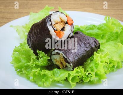 La cucina giapponese, Vagetarian tradizionale di riso giapponese maki sushi Roll roba con tofu e carote avvolte in Nori alghe servita sulla quercia verde. Foto Stock