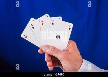 Mano trattiene ventaglio giocando a carte con quattro assi Foto Stock