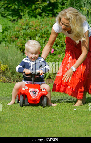 La madre gioca con suo figlio in giardino Foto Stock