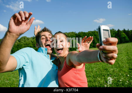 Coppia giovane prende una foto di loro stessi con il cellulare Foto Stock