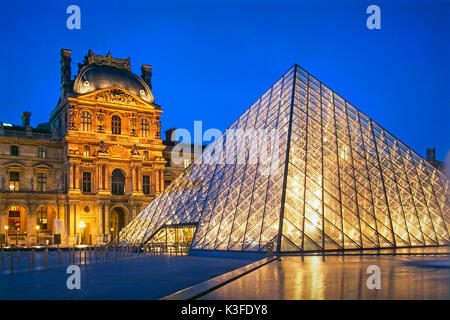 Illuminata la piramide di vetro di fronte al Louvre di Parigi Foto Stock