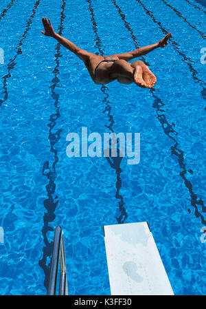 Uomo al tuffo in piscina di Springboard Foto Stock