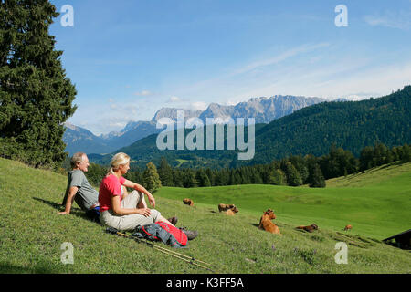 Giovane su un prato davanti al panorama di montagna gamma Wetterstein Foto Stock