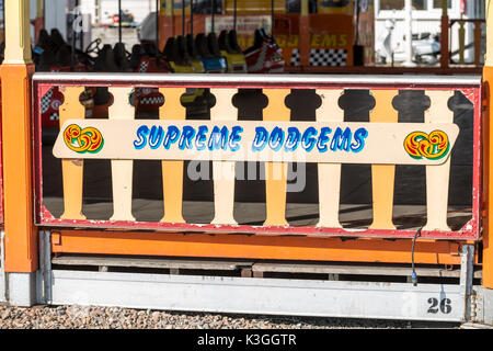 Un colorato dipinte a mano e firmare per una corsa dodgems presso un parco di divertimenti di viaggio a Worthing, West Sussex, Regno Unito. Foto Stock