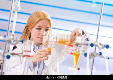 Femmina assistente di laboratorio con esperimento di chimica in laboratorio scientifico Foto Stock