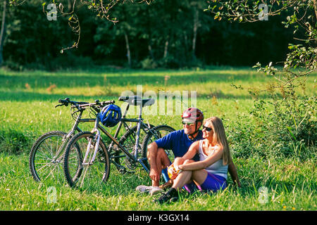 Giovane vicino mountain bike fa rompere su un prato Foto Stock