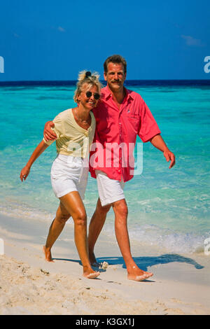 Una coppia passa per una passeggiata in spiaggia (Maldive) Foto Stock