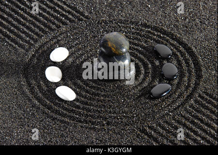 Giapponese giardino zen con yin e yang di pietre in sabbia Foto Stock