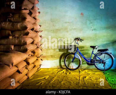 Blue bike parcheggiata in un colorato magazzino del grano, Bangkok, Thailandia. Foto Stock