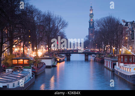 Paesi Bassi, Amsterdam, lungo il canale Prinsengracht, verso Westerkerk chiesa crepuscolo Foto Stock