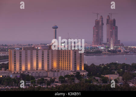 I UAE Abu Dhabi, elevati skyline vista su Hilton Hotel e Marina Isola, crepuscolo Foto Stock