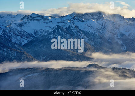 Vista dalla Herzogstand sul Soierngruppe e il bosco circostante con la nebbia. Foto Stock