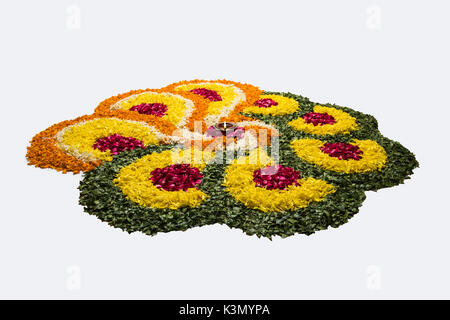 Flower rangoli di Diwali o pongal o onam realizzati utilizzando calendula o zendu fiori rosso e petali di rosa su sfondo bianco con diwali diya Foto Stock