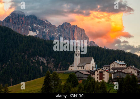 Il borgo di Colle Santa Lucia, in provincia di Belluno, arroccato su una collina verde (da qui il nome) ha una splendida vista su due importanti gruppi di montagne che formano lo sfondo: il Pelmo e nel caso di questa foto la magnifica spiers della parete nord del Civetta al tramonto. Dolomiti Foto Stock