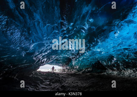 L'uomo all'interno di uno speleologo di ghiaccio sotto il ghiacciaio Vatnajokull, Vatnajokull national park, Est Islanda Islanda (MR) Foto Stock