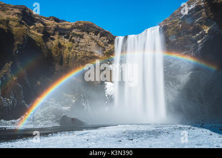 Skogafoss cascata, Skoga, Islanda. Rainbow sopra la cascata d'inverno. Foto Stock