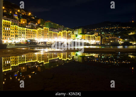 Luce case decorate riflettere sull'acqua sul lungomare. Camogli, Liguria, Italia Foto Stock
