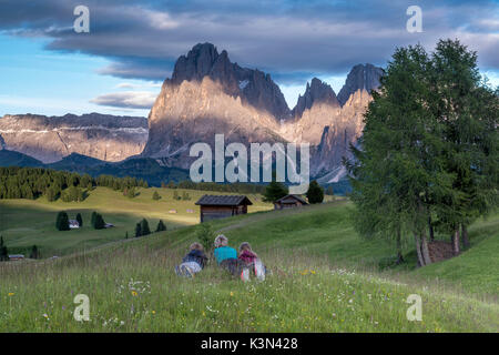 Alpe di Siusi / Seiser Alm, Dolomiti, Alto Adige, Italia. Gli alpinisti sull Alpe di Siusi ammirare il alpenglow. Sullo sfondo la Sella e Sassolungo/Sassolungo e Sassopiatto Foto Stock