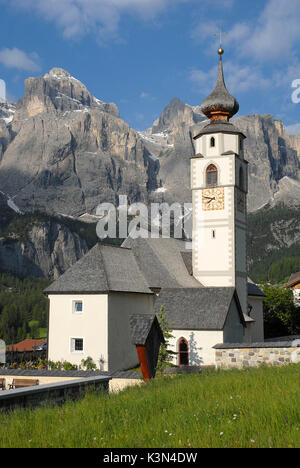 Colfosco, Dolomiti, Alto Adige, Italia. La chiesa di San Vigilio a Colfosco con la sella montagne Foto Stock