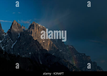 Passo Rolle, Dolomiti, Trentino, Italy. Rainbow nella Pala montagne con le vette della Cima di sfera e il Sass Maor Foto Stock