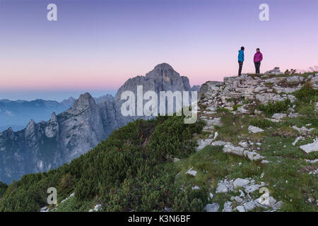 L'Europa, Italia, Veneto. Gli escursionisti sulla prima pala di San Lucano summit guardando il sorgere del sole. Dolomiti Agordine, Belluno, Italia Foto Stock