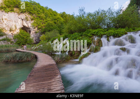 Il parco nazionale di Plitvice, Croazia. Una passerella e una cascata. Foto Stock