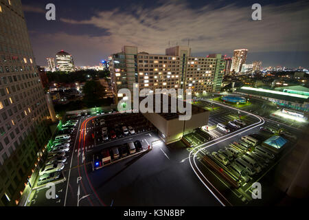Parcheggio la via della vettura i fari in transito durante la notte in una lunga exposur. Tokyo, Giappone Foto Stock