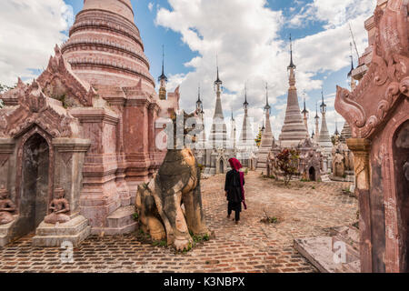 Kakku, Taunggyi, Stato Shan, Myanmar (Birmania). Una donna che cammina tra il 2478 stupa. Foto Stock