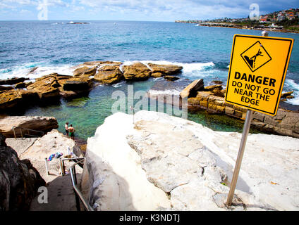 Segnaletica di pericolo sul bordo scogliera a Coogee Beach Foto Stock